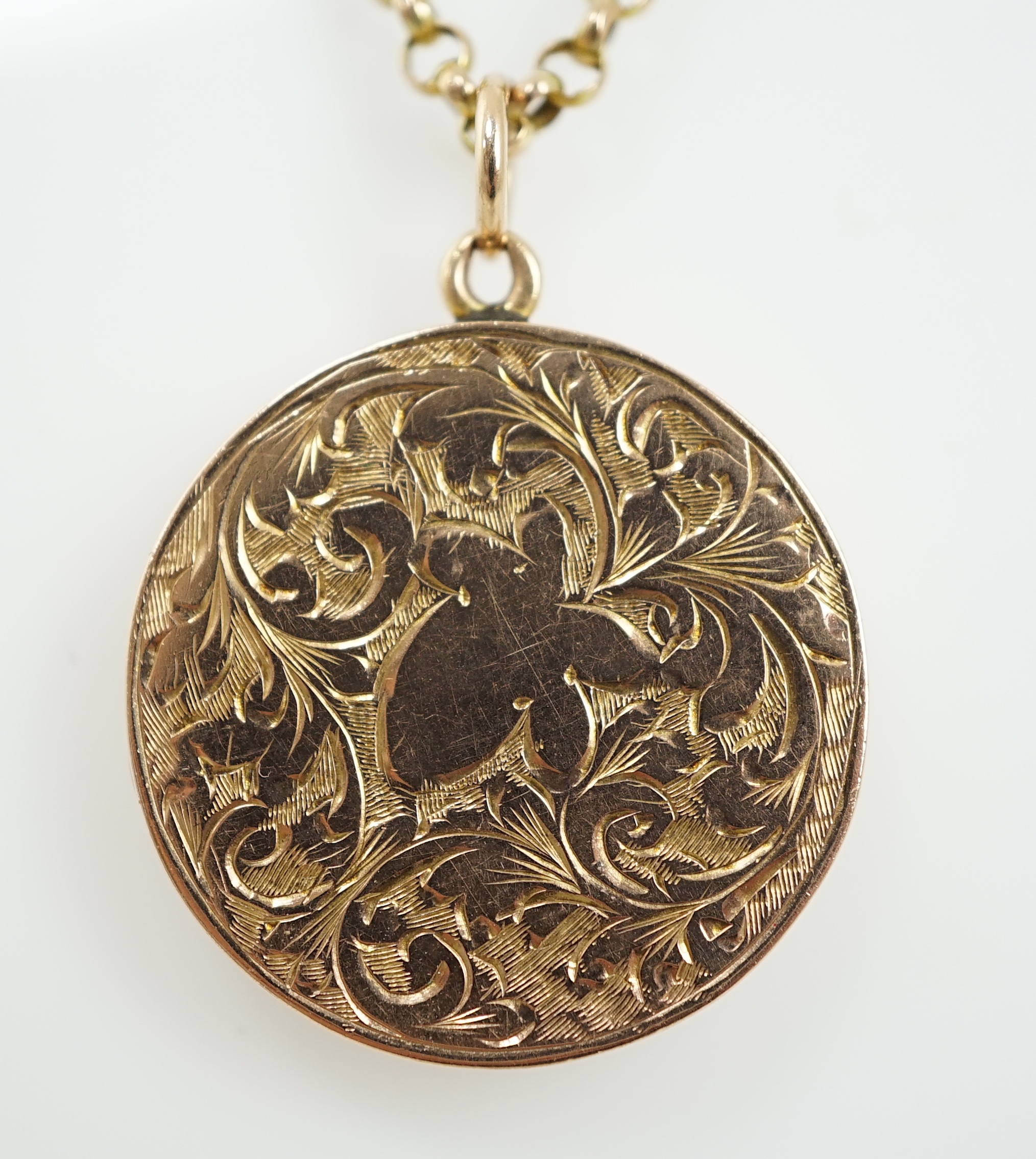 A George V engraved 9ct gold circular locket, diameter 25mm, on a 9ct chain, 45cm